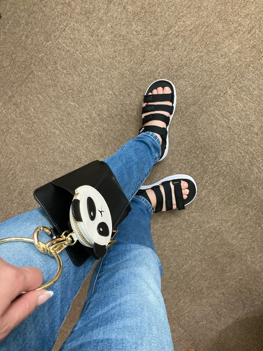 ブラック系のサンダル、ブルー系のデニムパンツ、ブラック系のショルダーバッグを着用したレディースの夏コーディネートの2枚目の写真