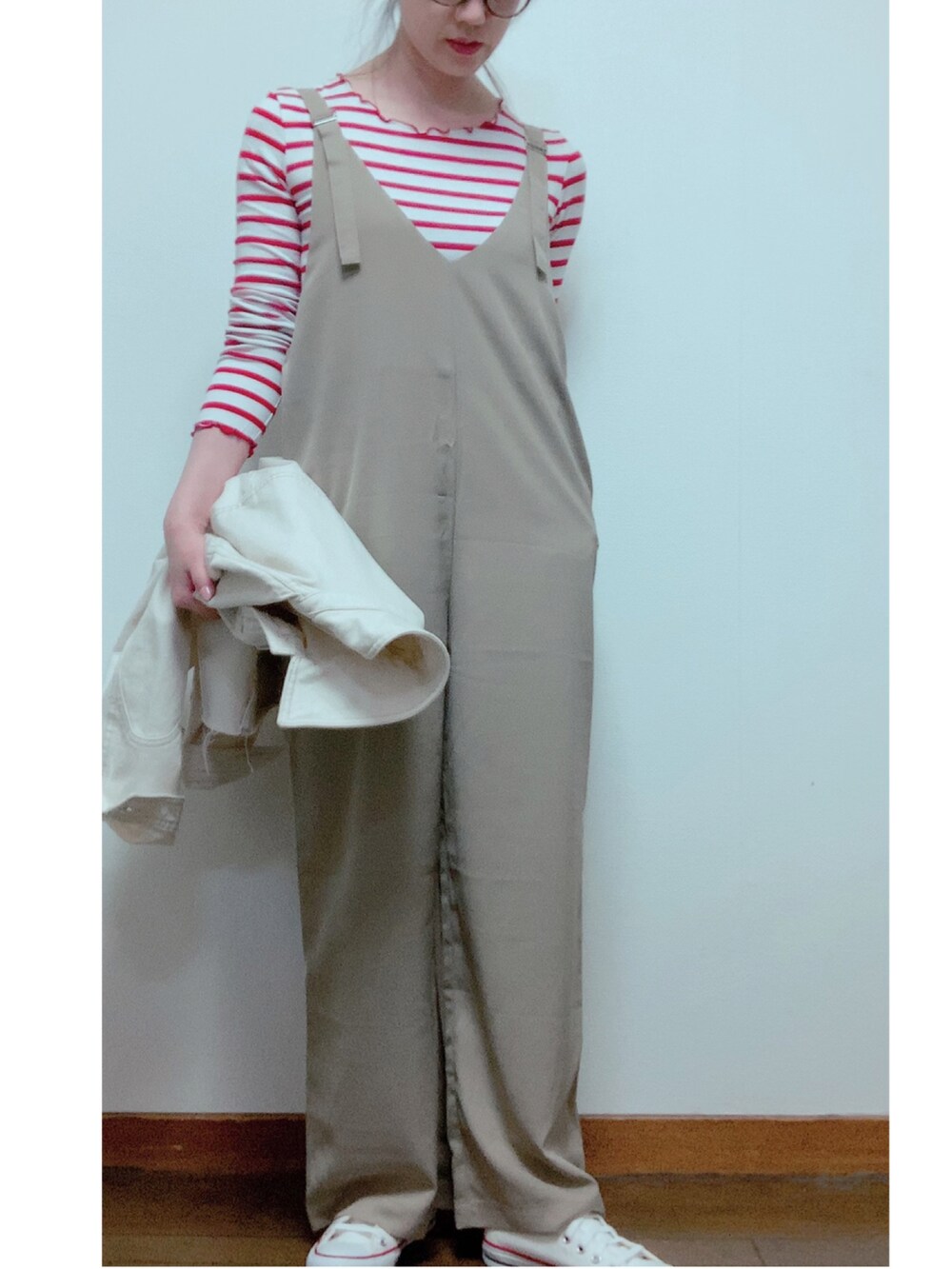 ホワイト系のスニーカー、ベージュ系のオールインワン・サロペット、ブラウン系のメガネを着用したレディースの春コーディネートの2枚目の写真