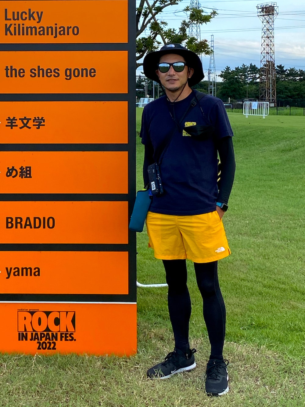 イエロー系のその他パンツ、ブルー系のTシャツ/カットソー、ブラック系のハットを着用したメンズの夏コーディネートの2枚目の写真