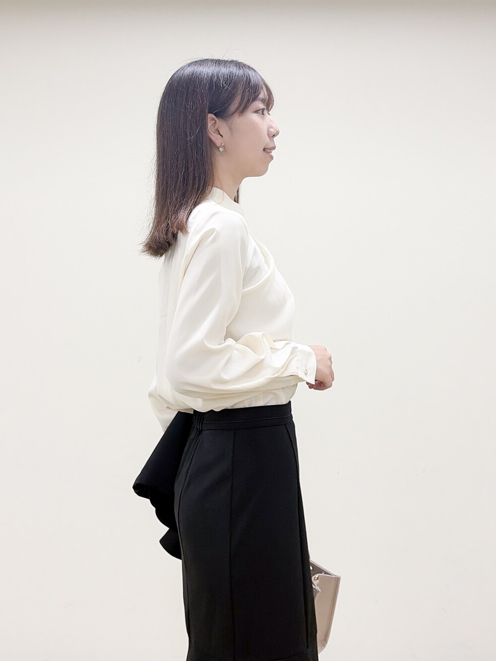 ホワイト系のシャツ/ブラウス、ブラック系のスカート、ベージュ系のトートバッグを着用したレディースの秋コーディネートの7枚目の写真