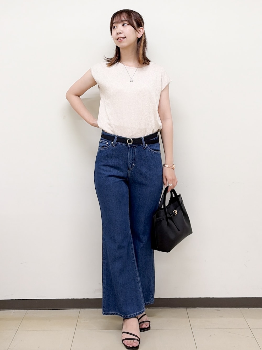 ピンク系のニット/セーター、ブルー系のデニムパンツ、ブラック系のトートバッグを着用したレディースの夏コーディネートの2枚目の写真