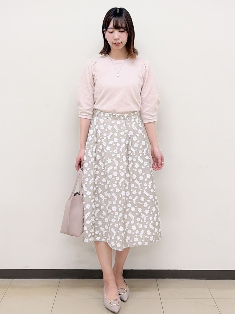 ベージュ系のパンプス、ベージュ系のスカート、ピンク系のニット/セーターを着用したレディースの春コーディネートの3枚目の写真