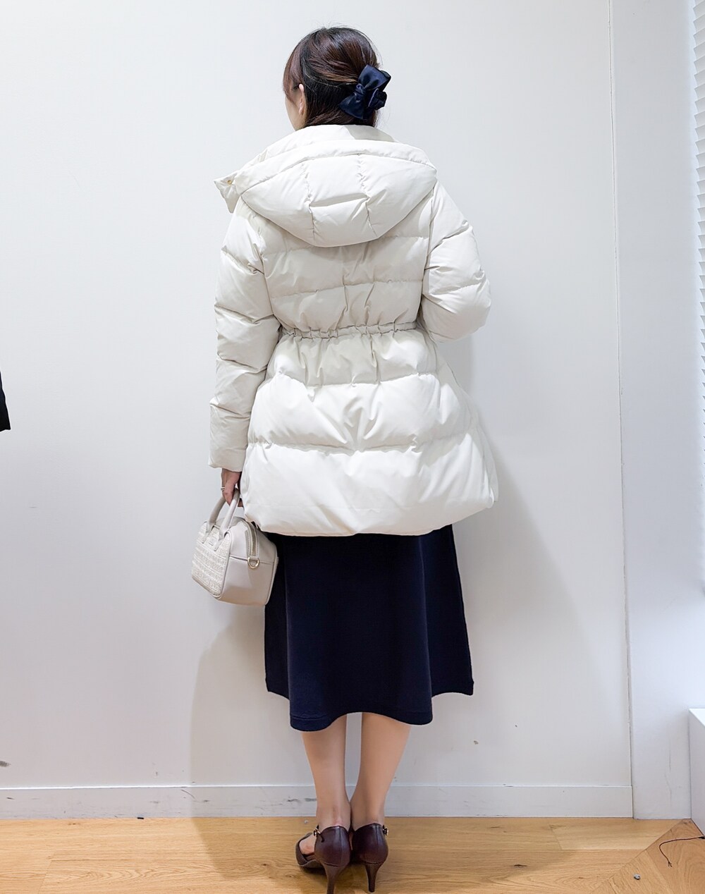 レッド系のパンプスを着用したレディースの秋コーディネートの3枚目の写真