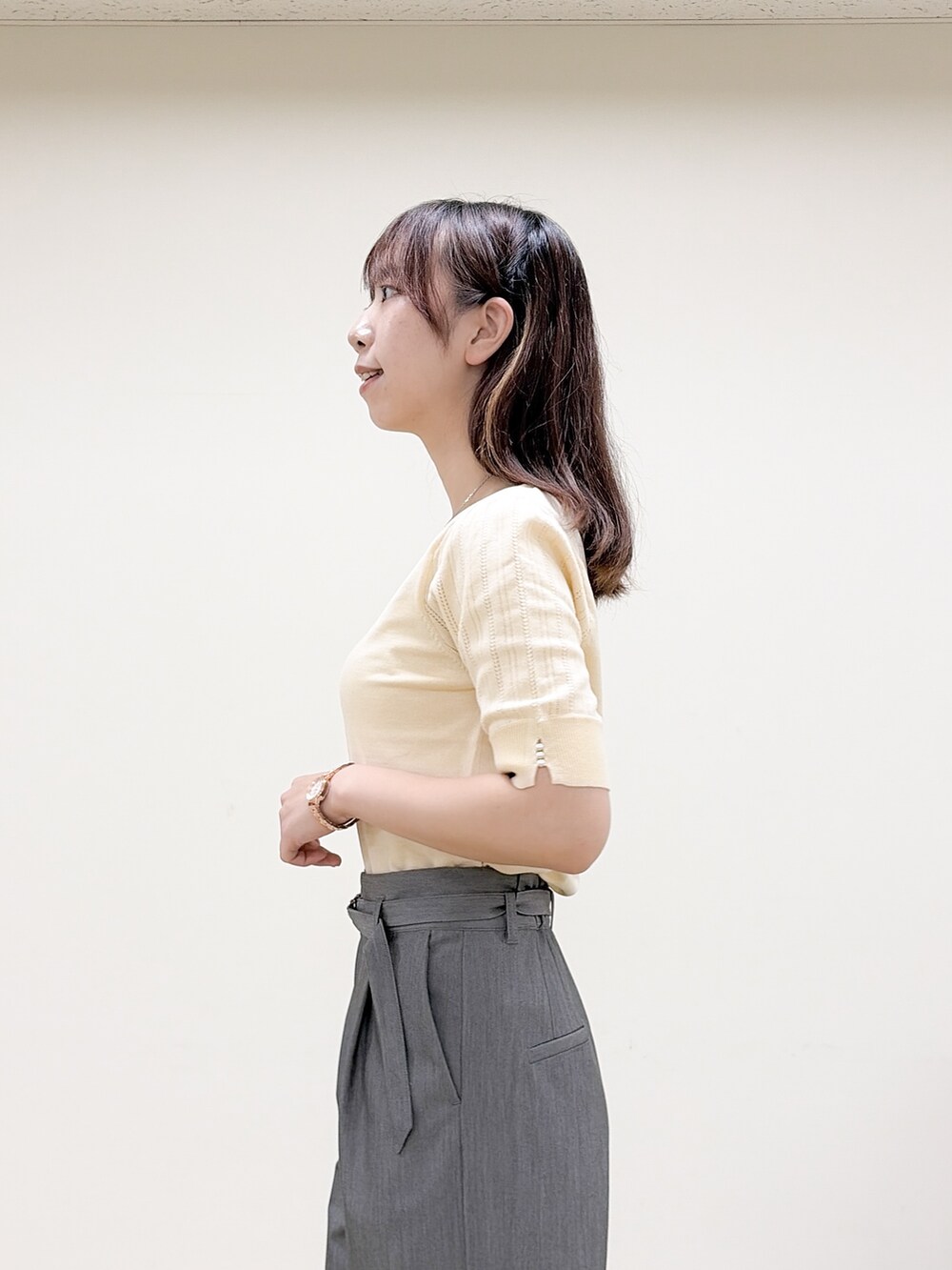イエロー系のニット/セーター、グレー系のその他パンツ、ベージュ系のトートバッグを着用したレディースの秋コーディネートの6枚目の写真