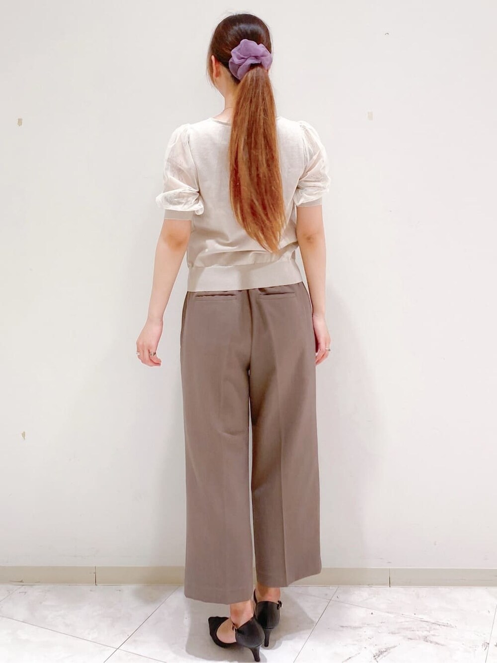 ベージュ系のニット/セーター、ブラウン系のその他パンツ、ホワイト系のトートバッグを着用したレディースの夏コーディネートの6枚目の写真