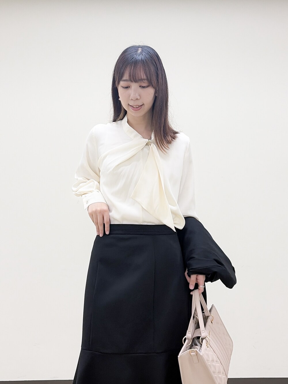 ホワイト系のシャツ/ブラウス、ブラック系のスカート、ベージュ系のトートバッグを着用したレディースの秋コーディネートの6枚目の写真