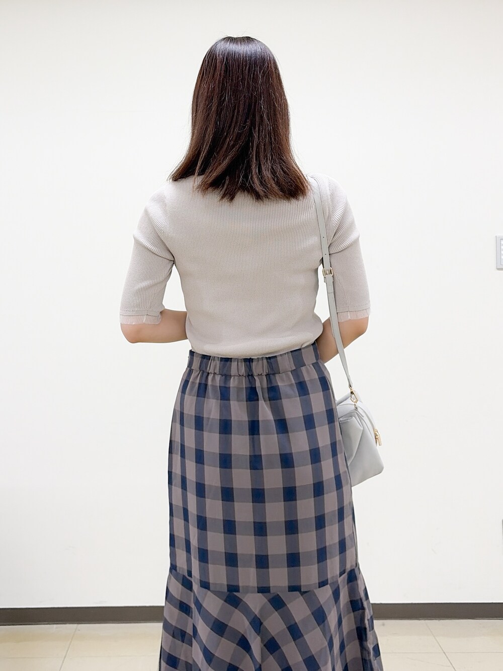 ベージュ系のニット/セーター、ブラウン系のスカート、グレー系のボストンバッグを着用したレディースの夏コーディネートの7枚目の写真