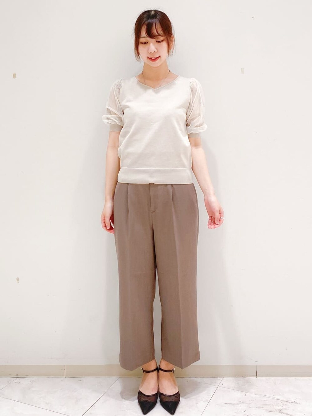 ベージュ系のニット/セーター、ブラウン系のその他パンツ、ホワイト系のトートバッグを着用したレディースの夏コーディネートの5枚目の写真