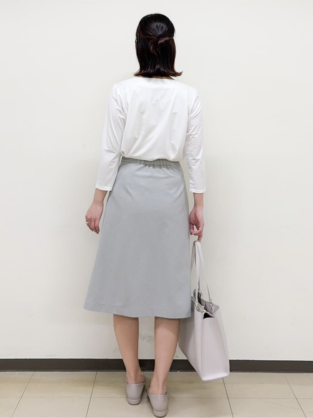 ベージュ系のパンプス、グレー系のスカート、グレー系のノーカラージャケットを着用したレディースの春コーディネートの8枚目の写真