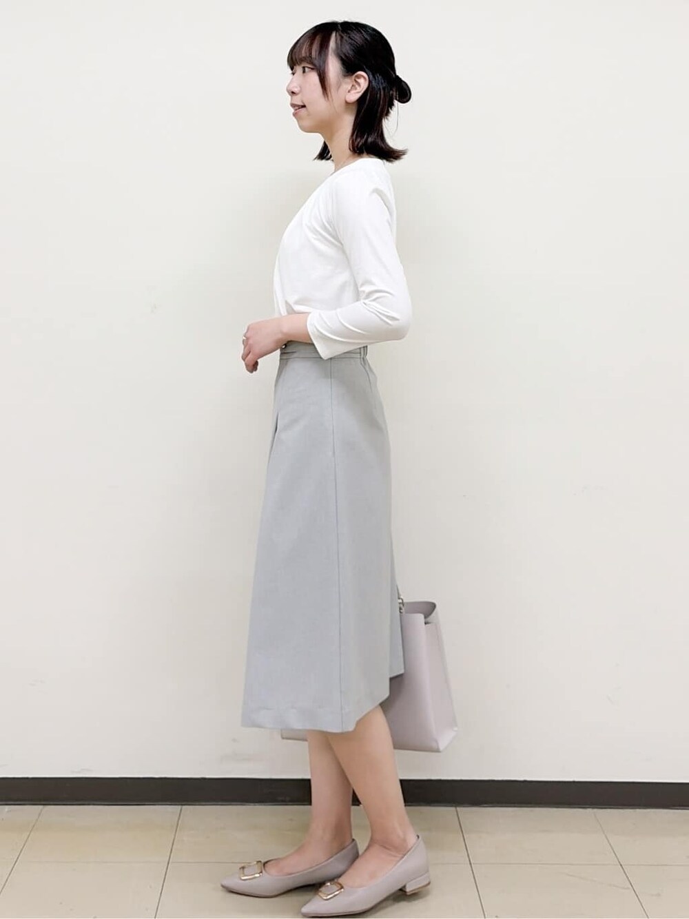 ベージュ系のパンプス、グレー系のスカート、グレー系のノーカラージャケットを着用したレディースの春コーディネートの7枚目の写真