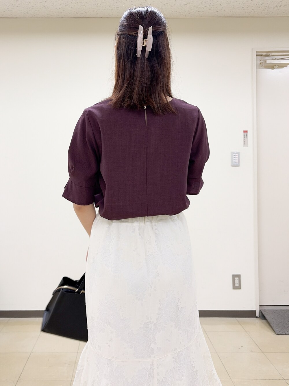 ホワイト系のスカート、ブラック系のトートバッグ、ブラック系のパンプスを着用したレディースの夏コーディネートの8枚目の写真