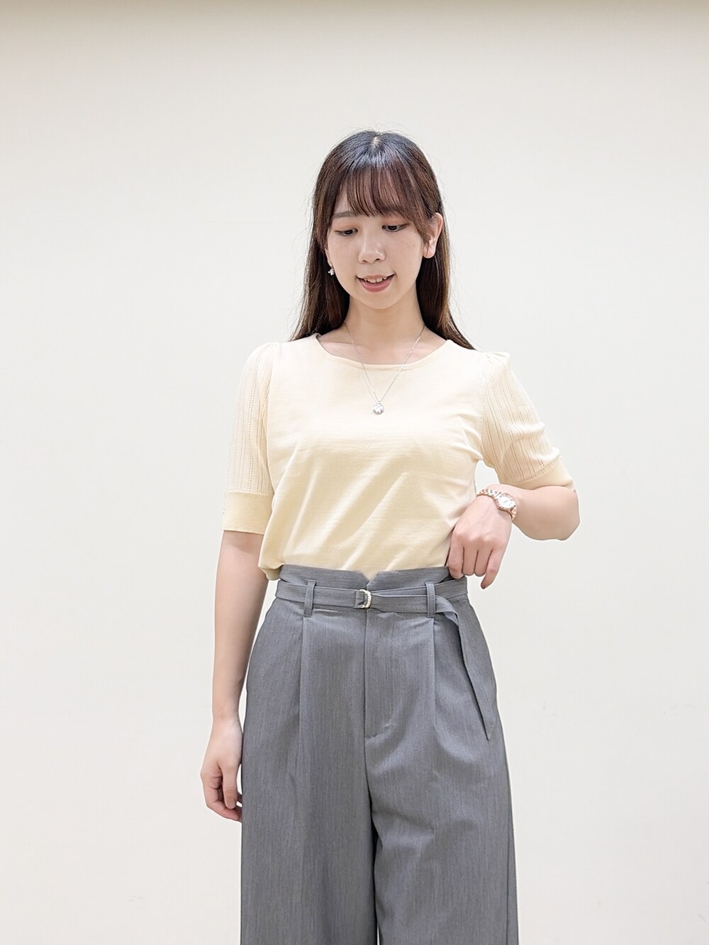 イエロー系のニット/セーター、グレー系のその他パンツ、ベージュ系のトートバッグを着用したレディースの秋コーディネートの5枚目の写真