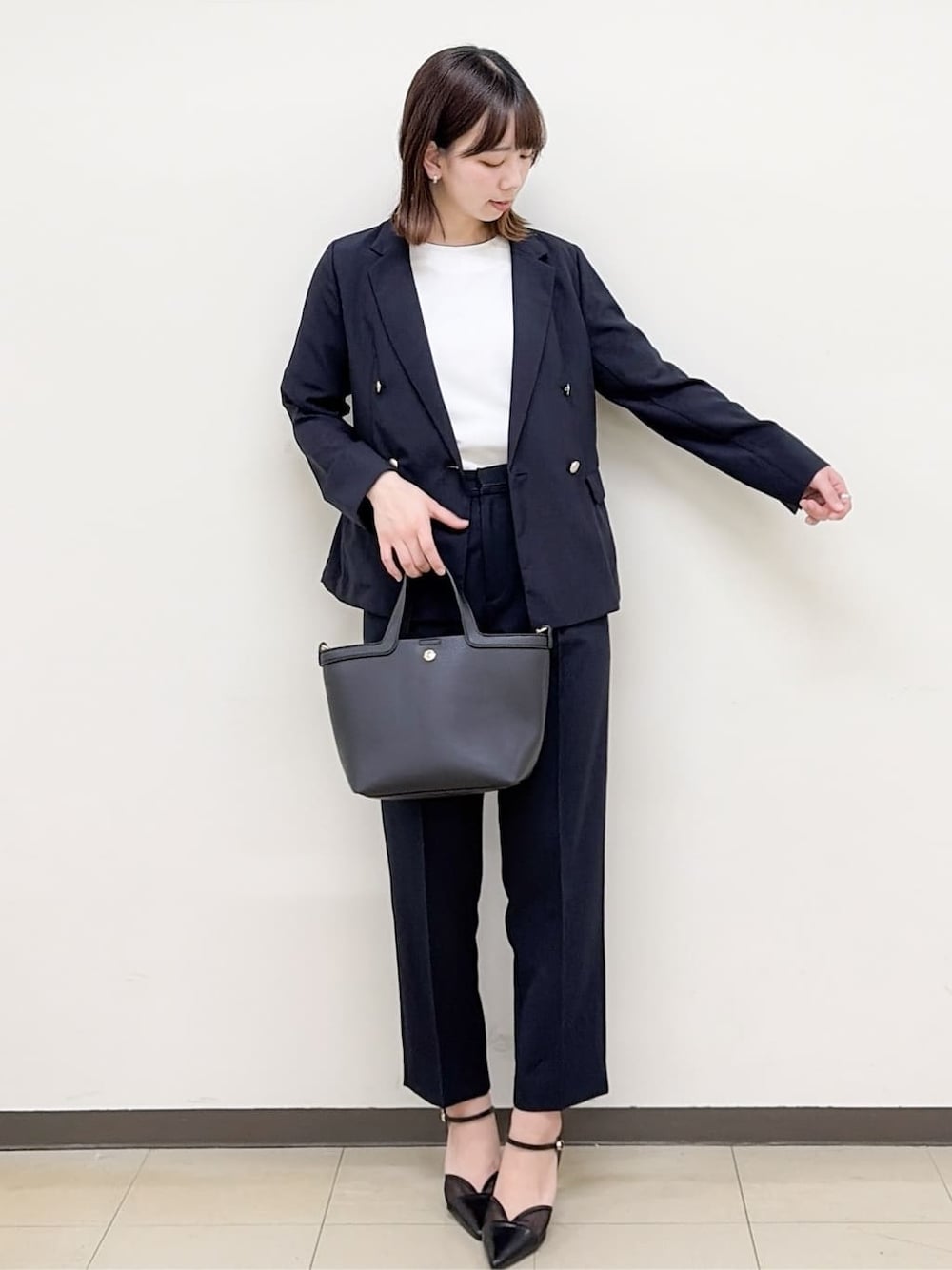 ブルー系のその他パンツ、ブラック系のパンプス、ブラック系のショルダーバッグを着用したレディースの春コーディネートの3枚目の写真