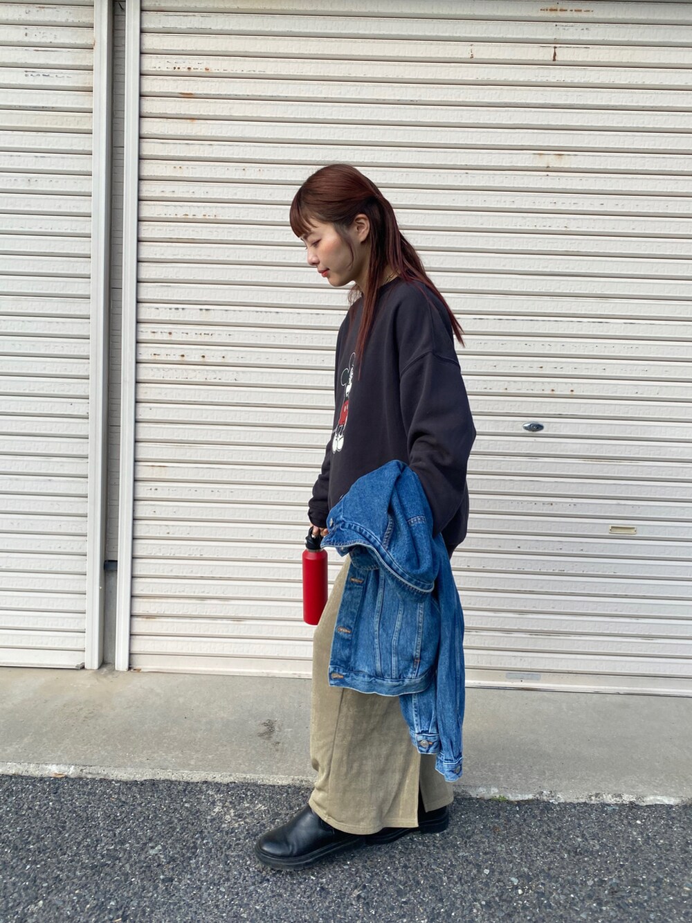 ブラック系のスウェット、ベージュ系のスカート、ブラック系のブーツを着用したレディースの冬コーディネートの2枚目の写真