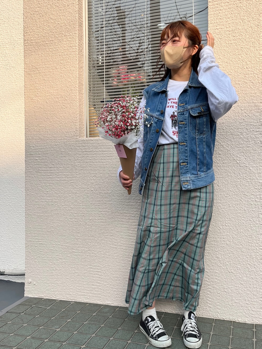 ホワイト系のTシャツ/カットソー、ブルー系のベスト、グリーン系のスカートを着用したレディースの春コーディネートの3枚目の写真