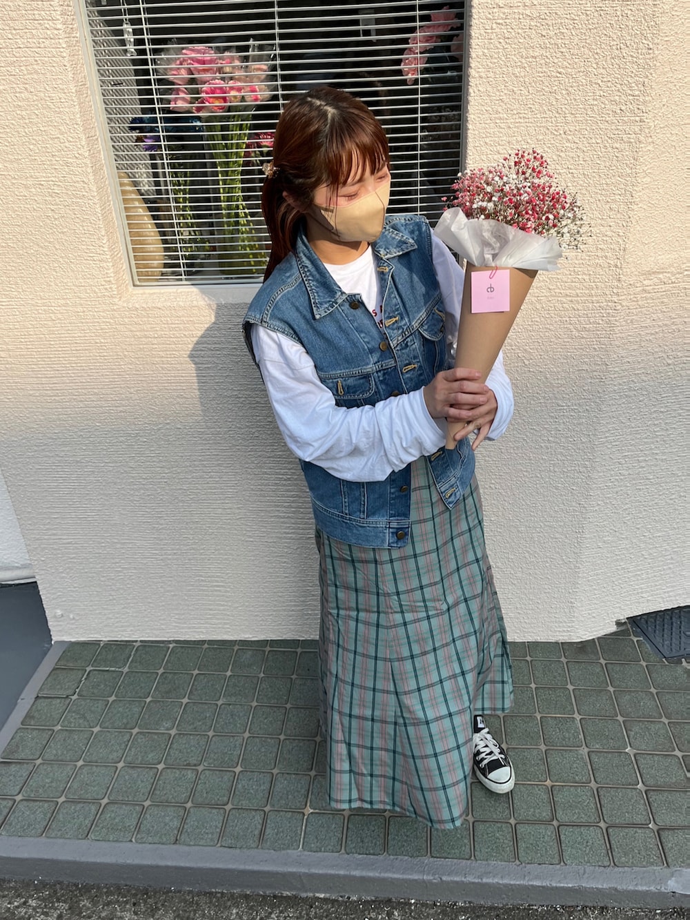 ホワイト系のTシャツ/カットソー、ブルー系のベスト、グリーン系のスカートを着用したレディースの春コーディネートの2枚目の写真