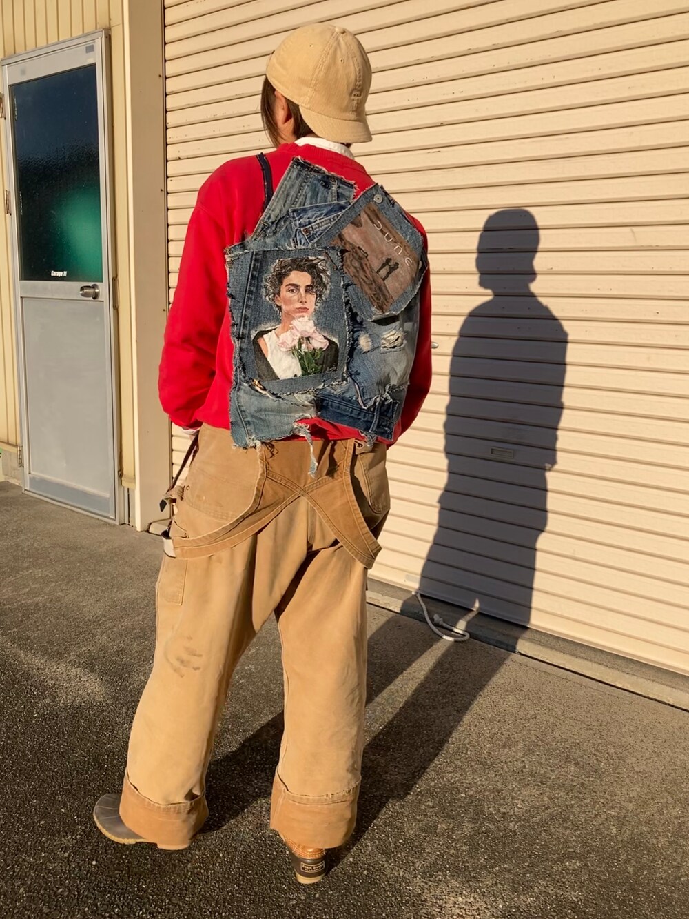 レッド系のスウェット、ブラウン系のブーツを着用したレディースの冬コーディネートの2枚目の写真