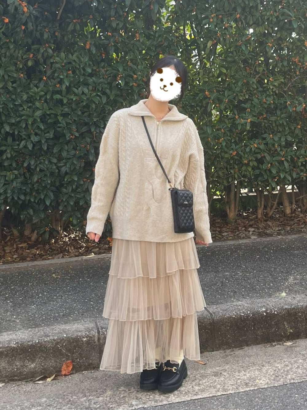 ベージュ系のニット/セーター、ベージュ系のスカート、ブラック系のバッグを着用したレディースの秋コーディネートの2枚目の写真
