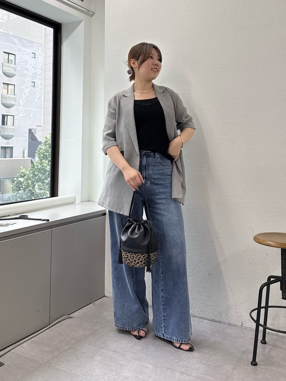 ブルー系のデニムパンツ、ブラック系のサンダル、ブラック系のキャミソールを着用したレディースの春コーディネートの3枚目の写真