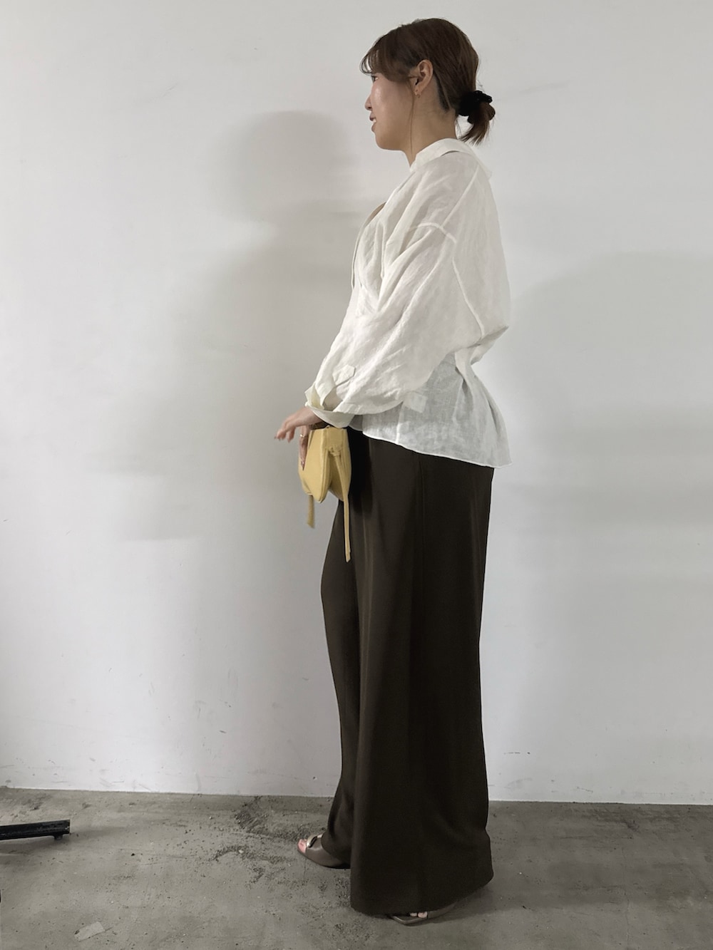 ブラウン系のその他パンツ、イエロー系のショルダーバッグ、ホワイト系のシャツ/ブラウスを着用したレディースの春コーディネートの2枚目の写真