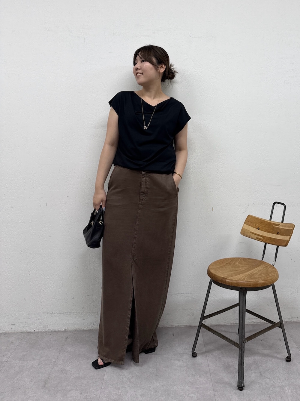 ブラウン系のスカート、ブラック系のサンダル、ブラック系のTシャツ/カットソーを着用したレディースの夏コーディネートの3枚目の写真