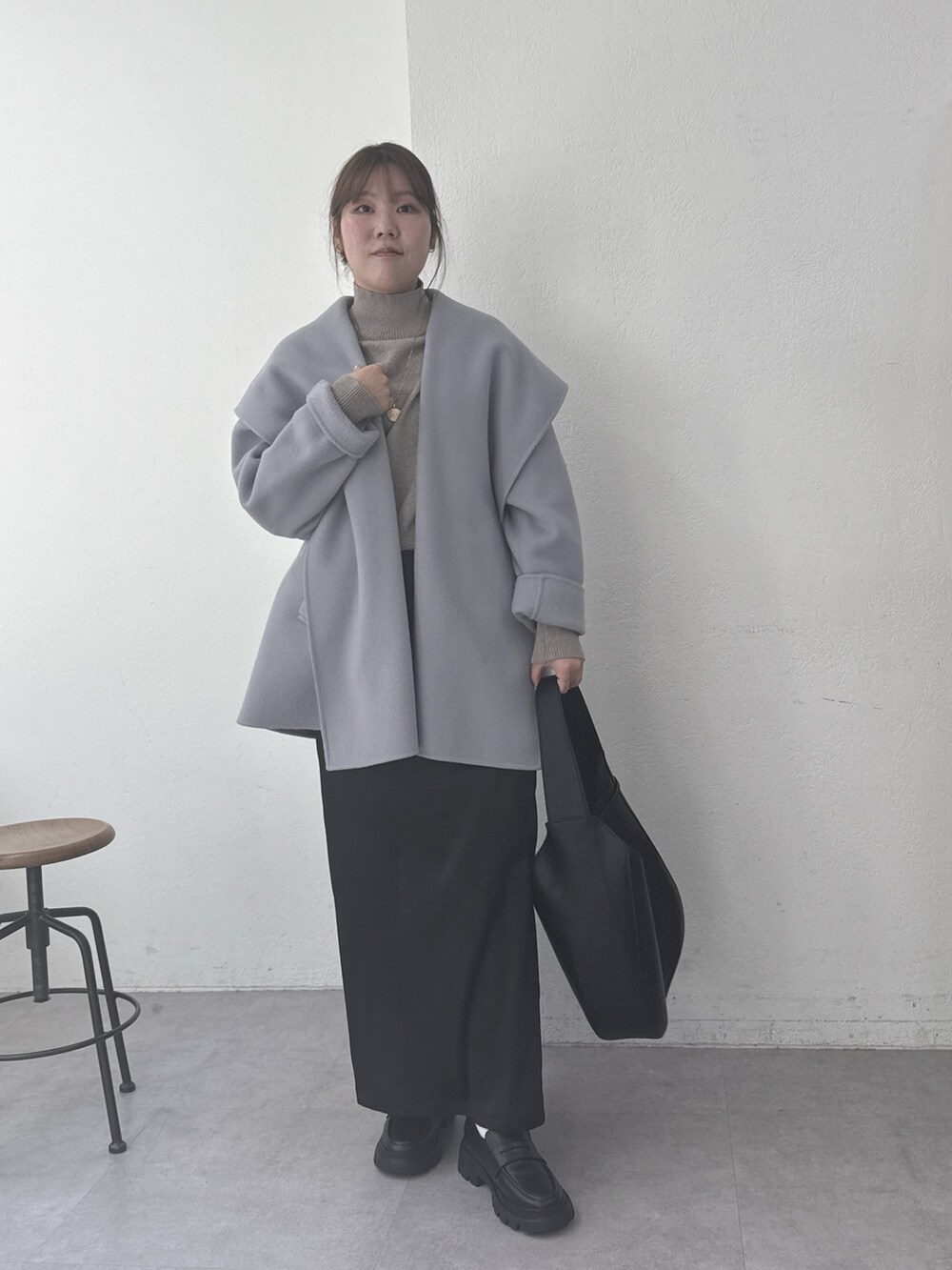 グレー系のその他アウター、ベージュ系のニット/セーター、ブラック系のショルダーバッグを着用したレディースの冬コーディネートの2枚目の写真