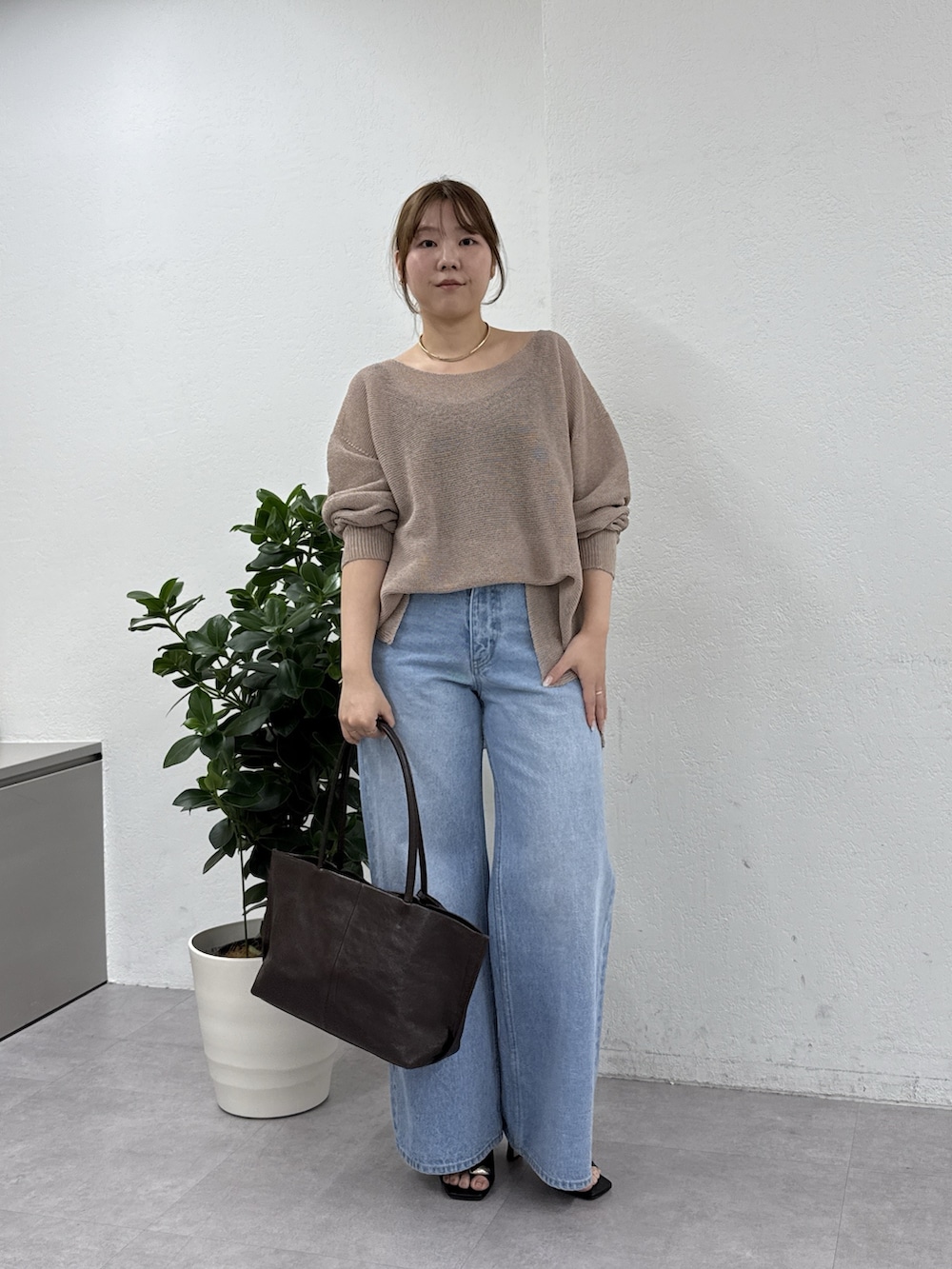 ベージュ系のニット/セーター、ブルー系のデニムパンツ、ブラック系のサンダルを着用したレディースの冬コーディネートの3枚目の写真