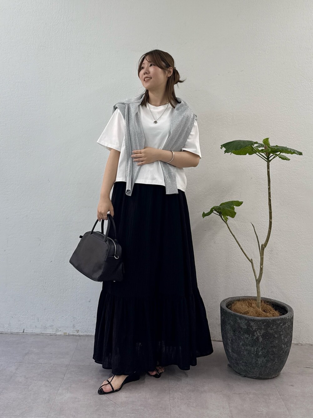 ブラック系のスカート、ブラック系のサンダル、ブラック系のボストンバッグを着用したレディースの夏コーディネートの4枚目の写真