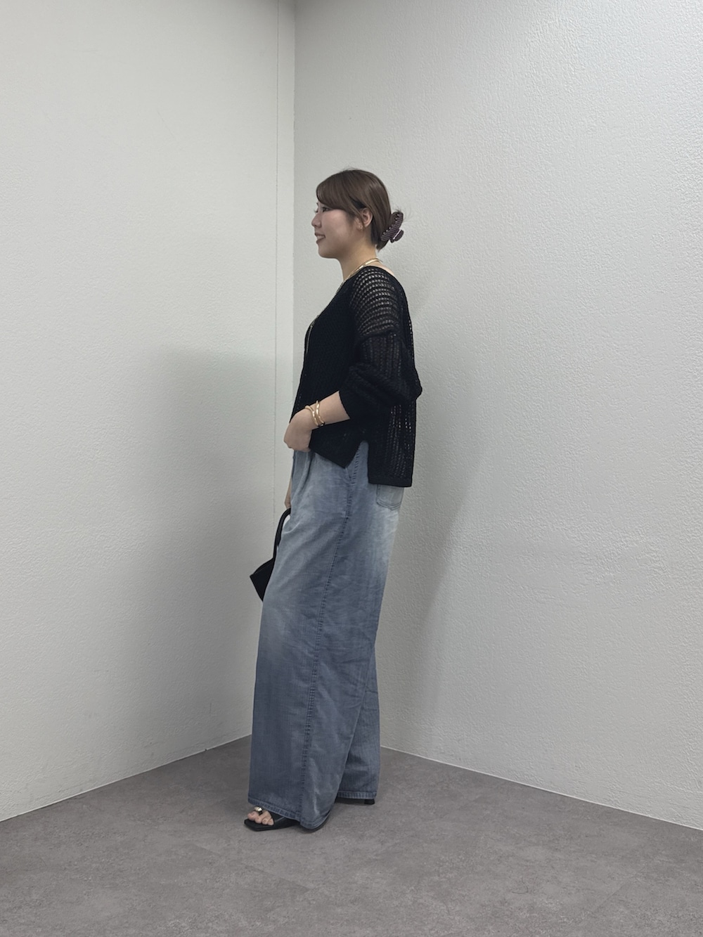 ブラック系のパーカー、ブルー系のその他パンツ、ブラック系のトートバッグを着用したレディースの春コーディネートの2枚目の写真