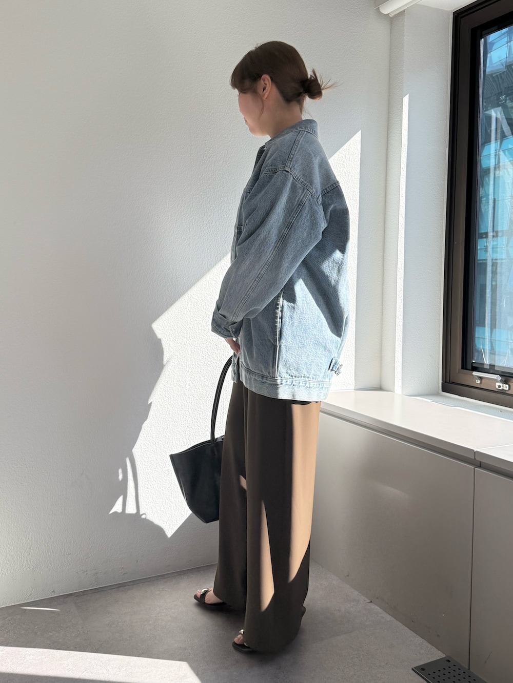 ブラウン系のその他パンツ、ブラック系のトートバッグ、ブルー系のベストを着用したレディースの冬コーディネートの3枚目の写真