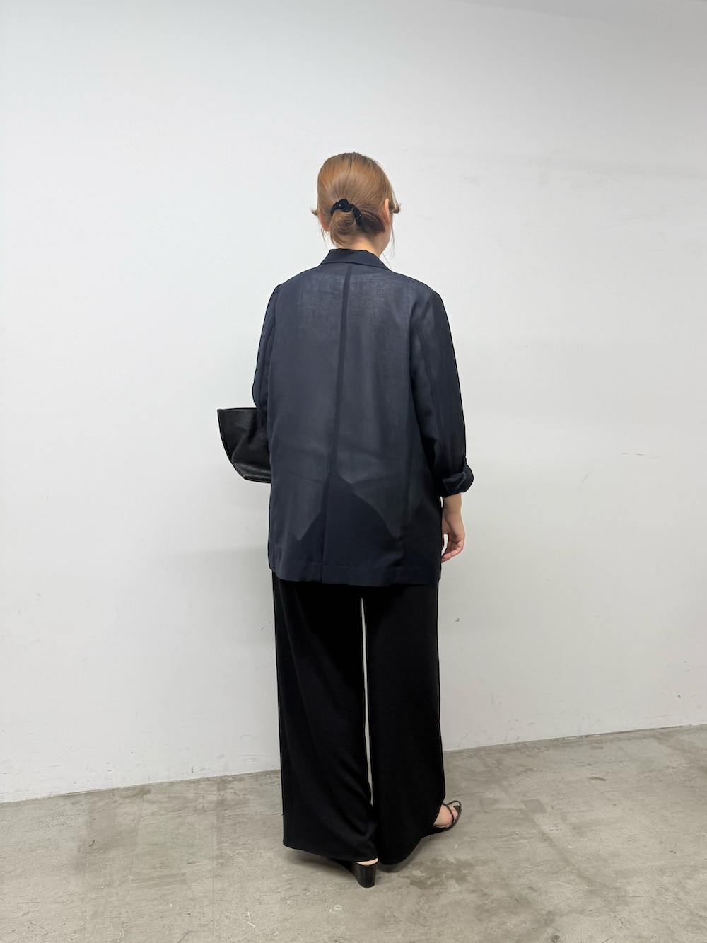 ブラック系のトートバッグ、ブルー系のテーラードジャケット、ホワイト系のシャツ/ブラウスを着用したレディースの春コーディネートの3枚目の写真