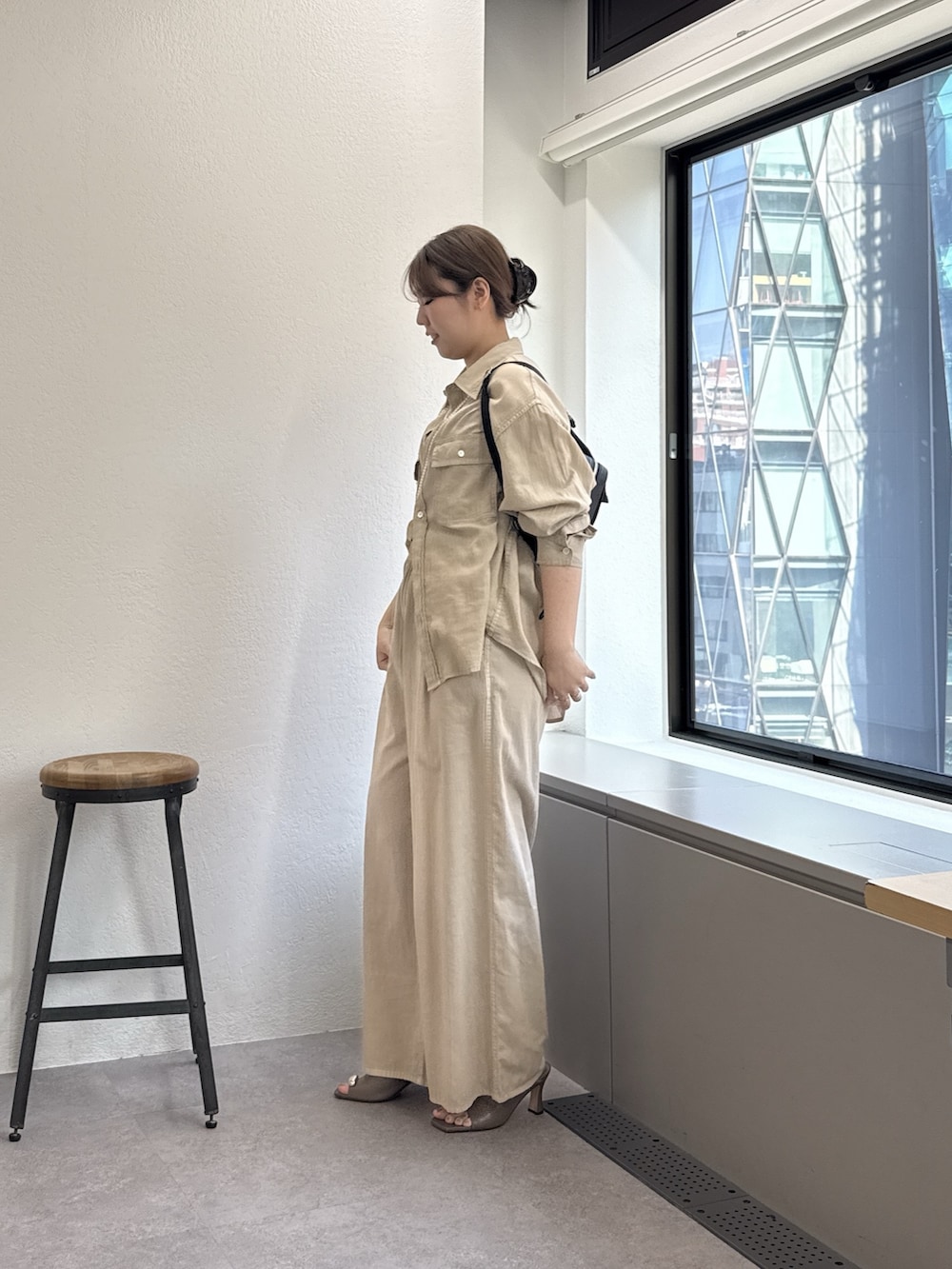 ベージュ系のその他パンツ、ベージュ系のシャツ/ブラウス、ブラック系のショルダーバッグを着用したレディースの春コーディネートの2枚目の写真