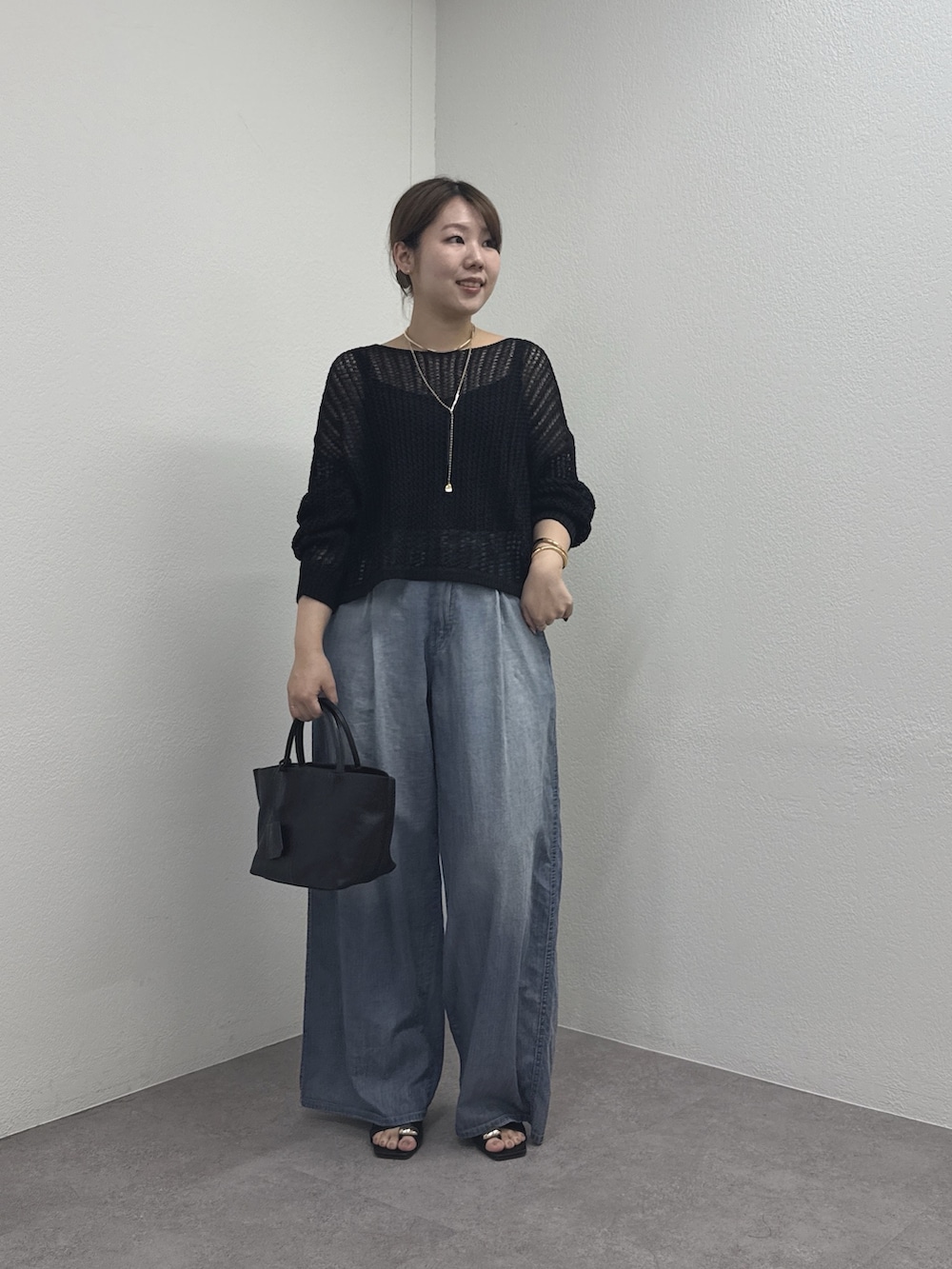 ブラック系のパーカー、ブルー系のその他パンツ、ブラック系のトートバッグを着用したレディースの春コーディネートの5枚目の写真