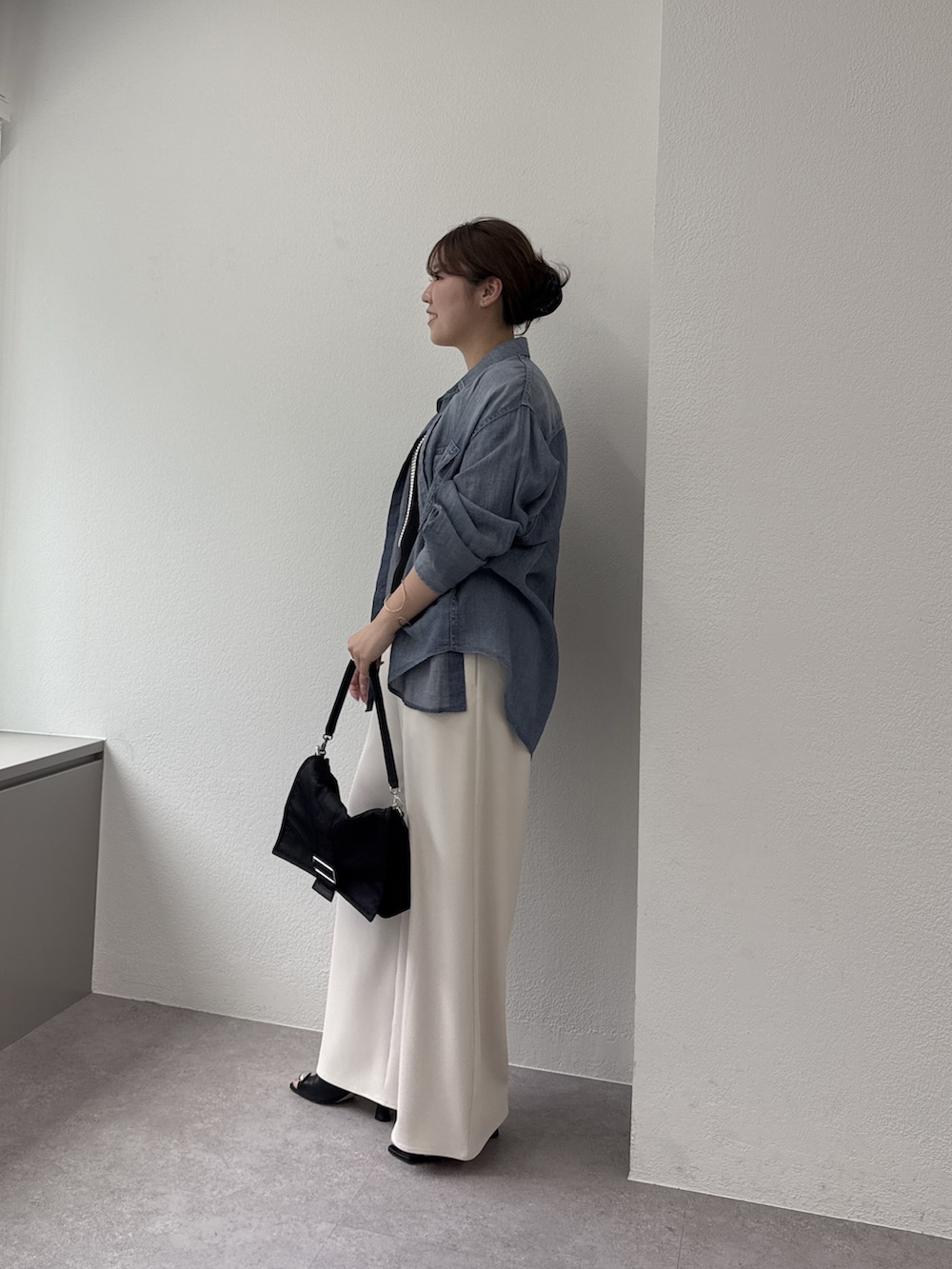 ベージュ系のその他パンツ、ブラック系のショルダーバッグ、ブルー系のシャツ/ブラウスを着用したレディースの春コーディネートの2枚目の写真