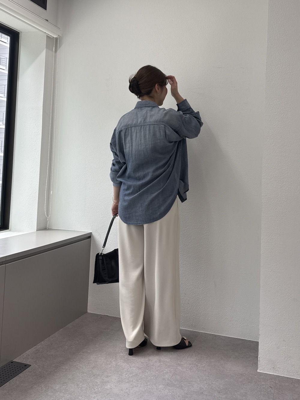 ベージュ系のその他パンツ、ブラック系のショルダーバッグ、ブルー系のシャツ/ブラウスを着用したレディースの春コーディネートの3枚目の写真