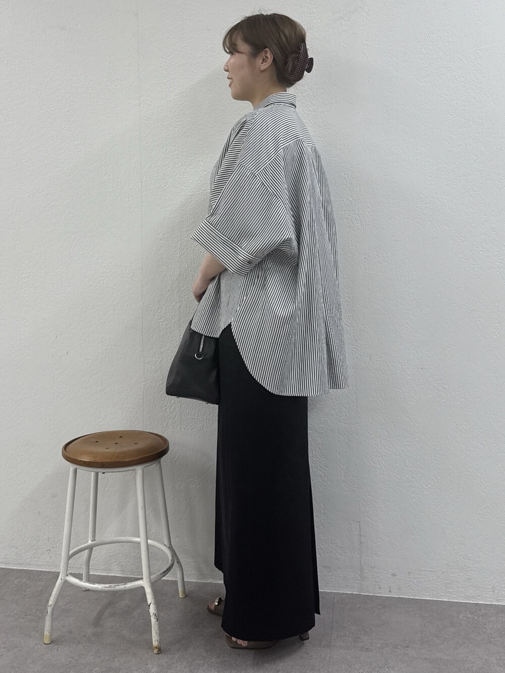 ブルー系のシャツ/ブラウス、ブラック系のボストンバッグ、ブラック系のスカートを着用したレディースの冬コーディネートの2枚目の写真