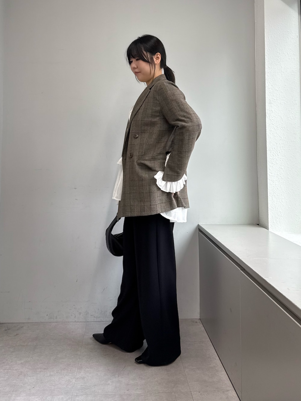 ブラック系のその他パンツ、ブラック系のトートバッグ、ブラウン系のベストを着用したレディースの秋コーディネートの2枚目の写真