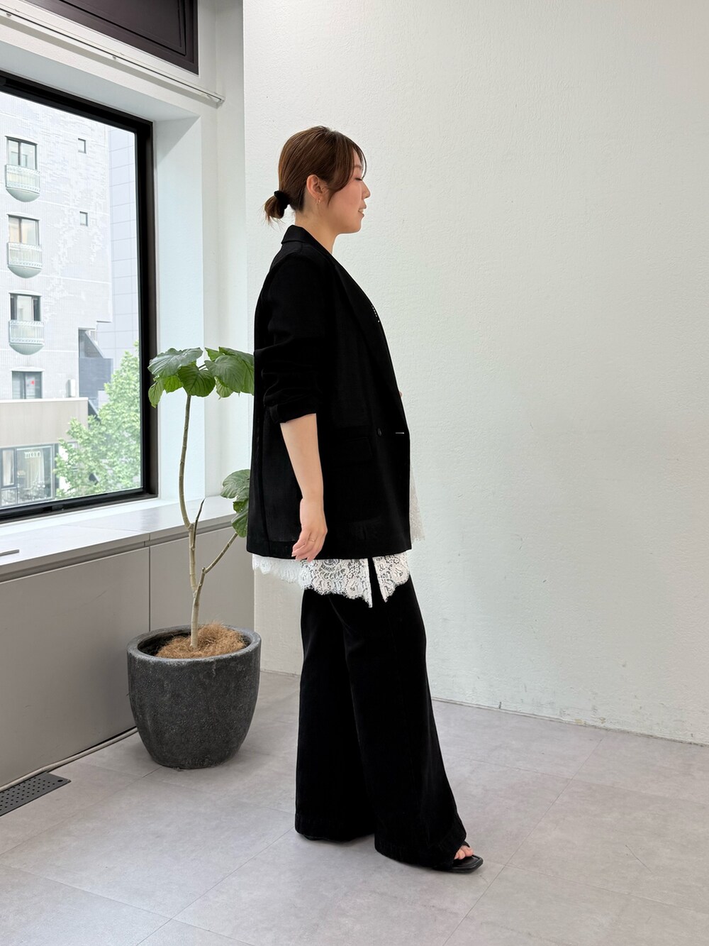 ブラック系のその他シューズ、ブラック系のデニムパンツ、ブルー系のハンドバッグを着用したレディースの春コーディネートの2枚目の写真