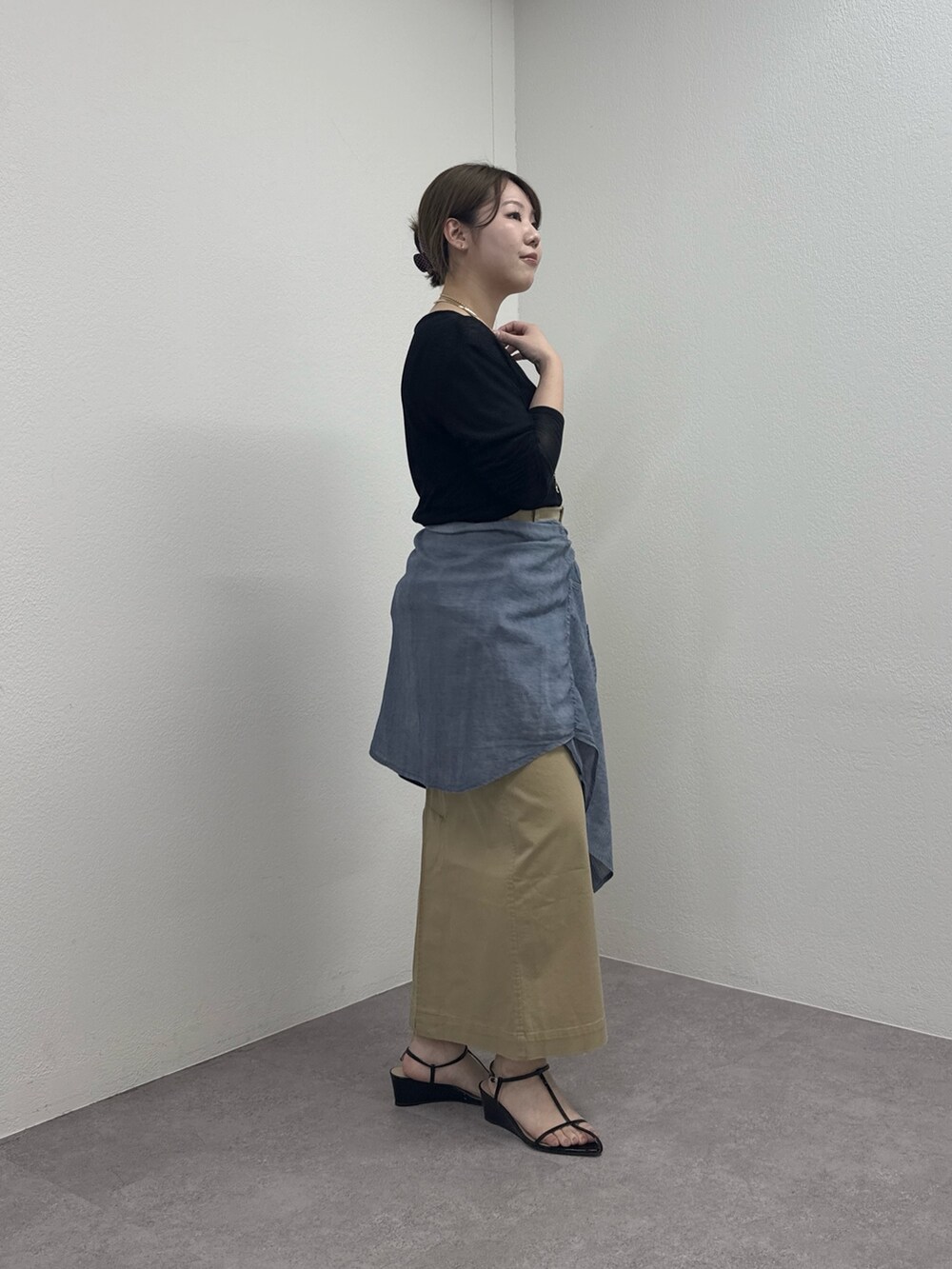 ブラック系のサンダル、ベージュ系のスカート、ブルー系のシャツ/ブラウスを着用したレディースの春コーディネートの3枚目の写真