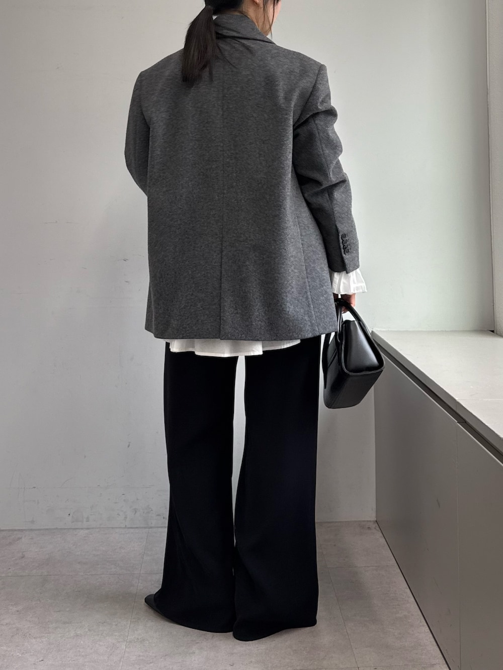 ブラック系のその他パンツ、ホワイト系のシャツ/ブラウス、グレー系のその他アウターを着用したレディースの秋コーディネートの3枚目の写真