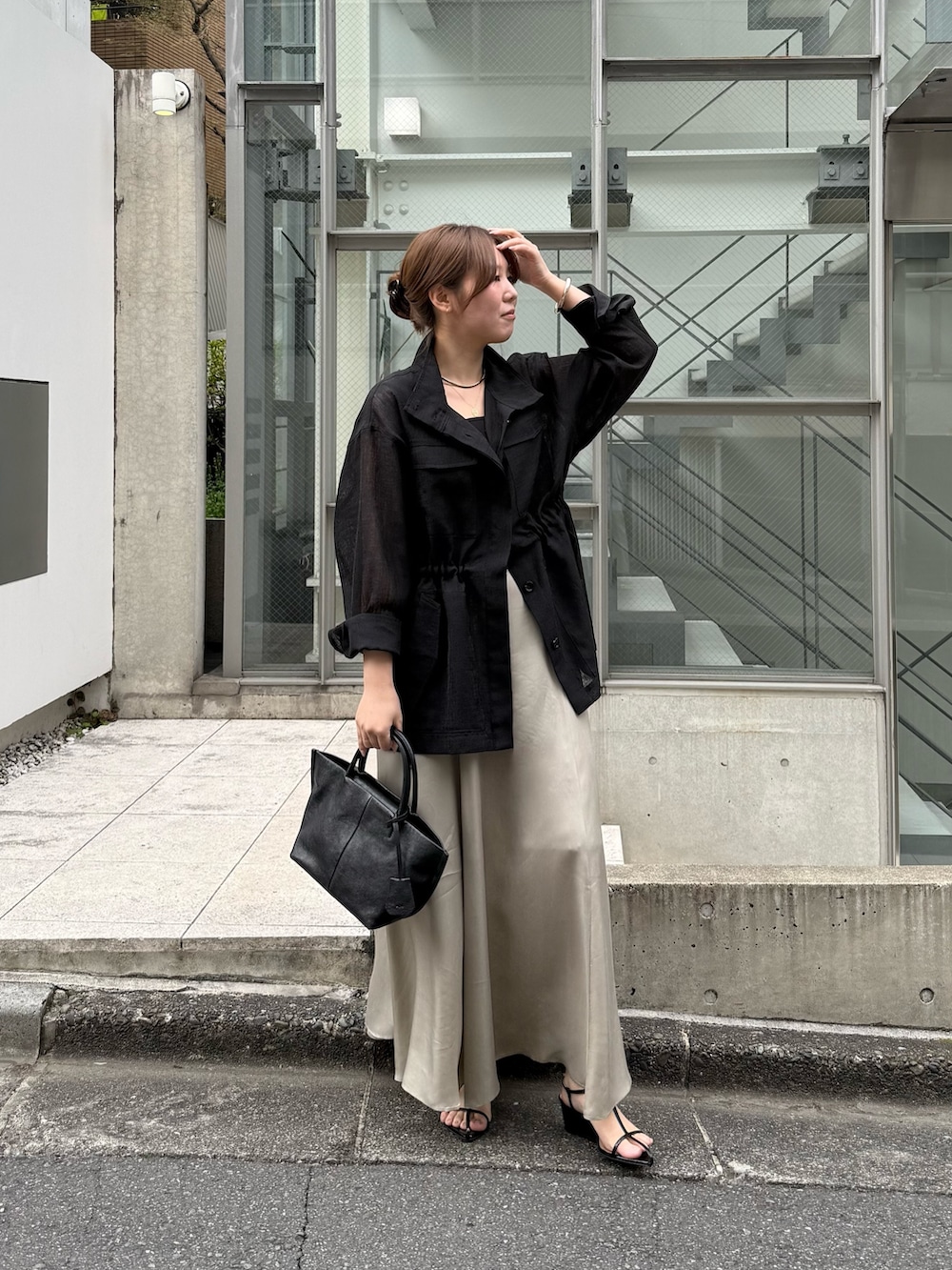 ブラック系のベスト、ブラック系のトートバッグ、ブラック系のニット/セーターを着用したレディースの春コーディネートの2枚目の写真