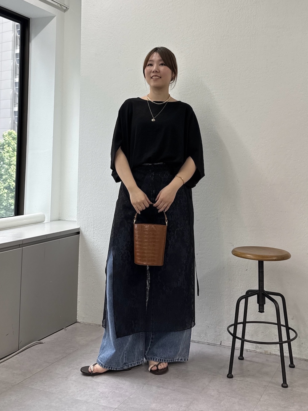 ブルー系のデニムパンツ、ブラウン系のその他シューズ、オレンジ系のショルダーバッグを着用したレディースの春コーディネートの4枚目の写真