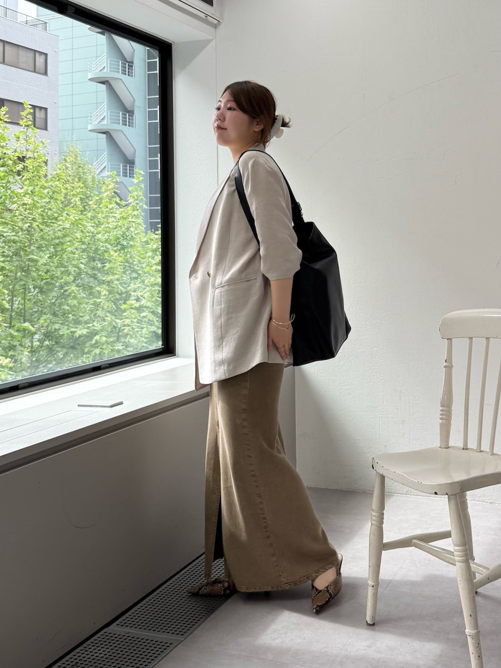 ブラウン系のパンプス、グリーン系のスカート、ホワイト系のキャミソールを着用したレディースの春コーディネートの2枚目の写真