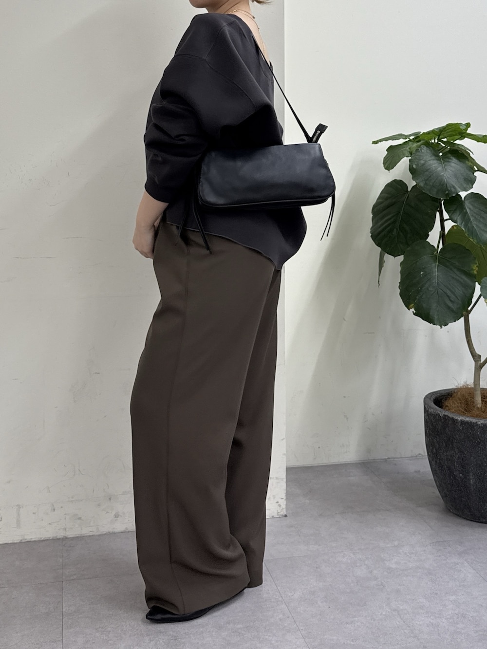 グレー系のその他パンツ、ブラック系のスリッポン、ブラウン系のTシャツ/カットソーを着用したレディースの冬コーディネートの2枚目の写真