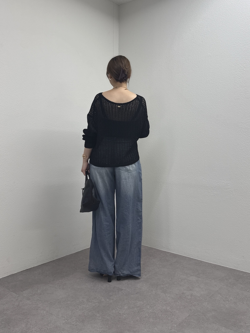 ブラック系のパーカー、ブルー系のその他パンツ、ブラック系のトートバッグを着用したレディースの春コーディネートの3枚目の写真