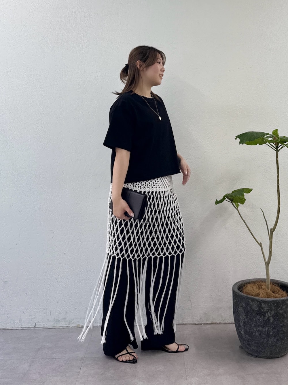 ブラック系のサンダル、ブラック系のその他パンツ、ホワイト系のスカートを着用したレディースの夏コーディネートの2枚目の写真