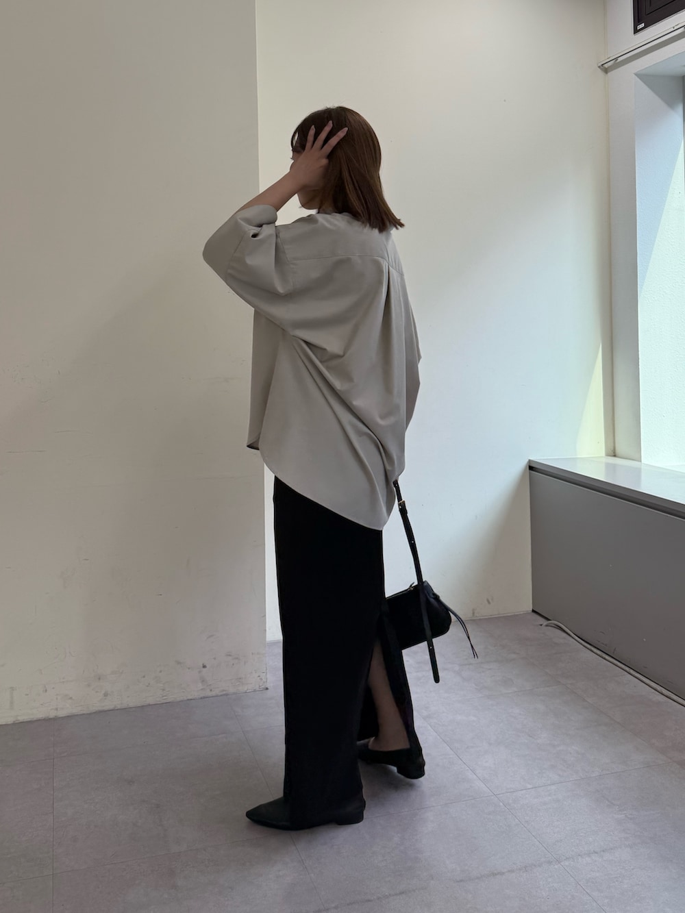 ベージュ系のシャツ/ブラウス、ブラック系のスカート、ブラック系のショルダーバッグを着用したレディースの冬コーディネートの3枚目の写真