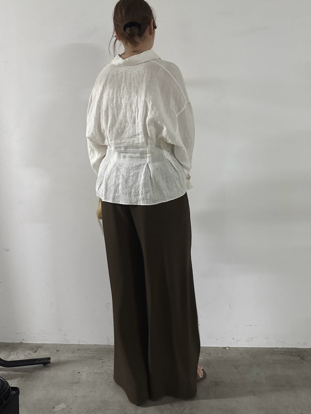 ブラウン系のその他パンツ、イエロー系のショルダーバッグ、ホワイト系のシャツ/ブラウスを着用したレディースの春コーディネートの3枚目の写真