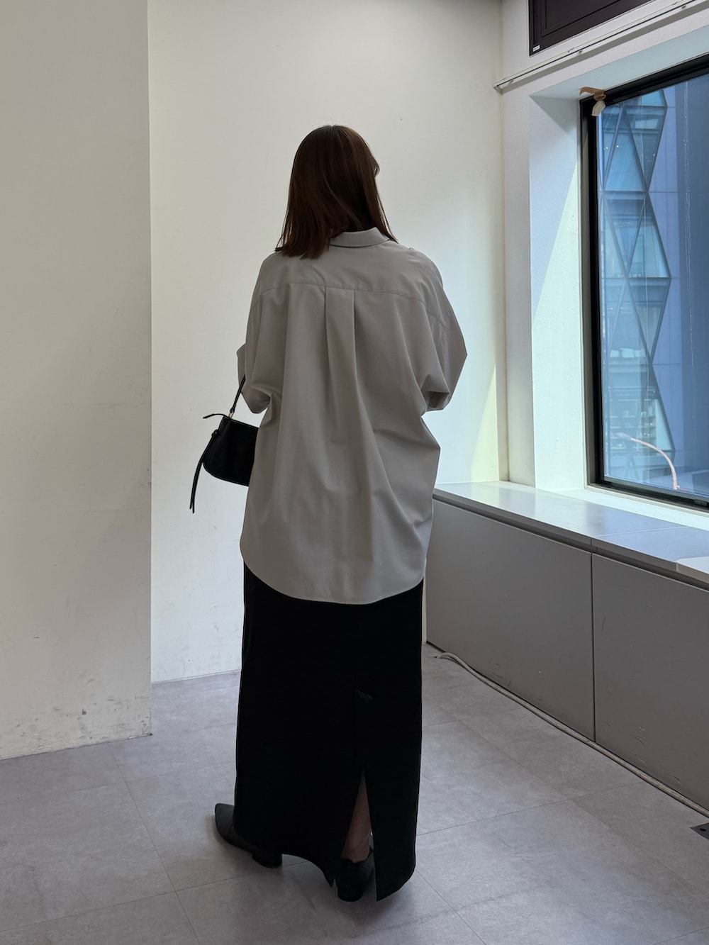 ベージュ系のシャツ/ブラウス、ブラック系のスカート、ブラック系のショルダーバッグを着用したレディースの冬コーディネートの4枚目の写真