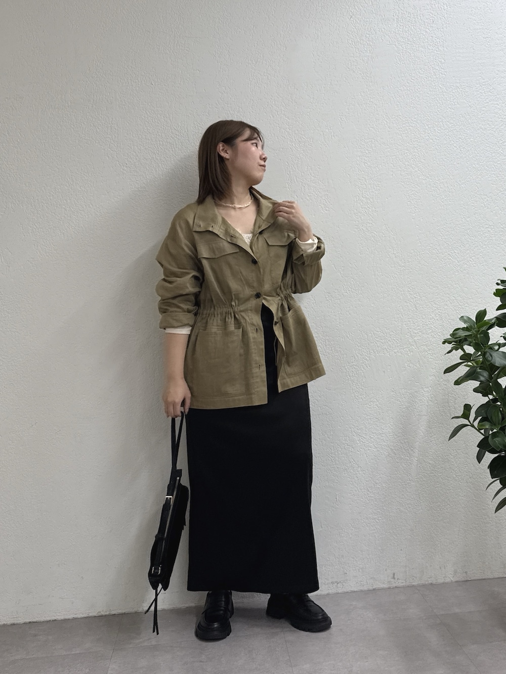 ブラック系のスカート、グリーン系のその他アウター、ホワイト系のTシャツ/カットソーを着用したレディースの冬コーディネートの4枚目の写真